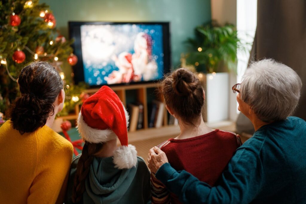 obitelj se okupila ispre televizora kako bi zajedno uživali u filmskoj večeri uz božićne filmove